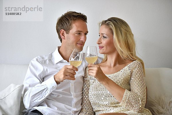 Mann  Frau  Paar auf Sofa  verliebt  Wein  Glas übereinander