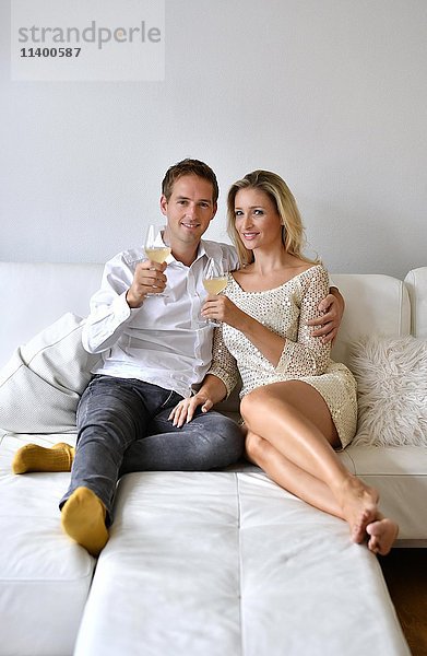 Mann  Frau  Paar auf Sofa  verliebt  Wein  Glas  in die Kamera schauen