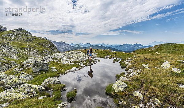 Wanderer am kleinen Bergsee mit Alpenpanorama  Schladminger Tauern  Schladming  Steiermark  Österreich  Europa