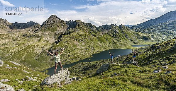 Drei Wanderer stehen auf Felsen vor Berglandschaft  Niederer Giglachsee  Rohrmoos-Obertal  Schladminger Tauern  Schladming  Steiermark  Österreich  Europa