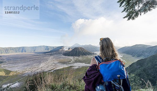Tourist vor Landschaft  rauchender Vulkan Mount Bromo  Mt. Batok im Vordergrund  Mt. Kursi im Hintergrund  Mt. Gunung Semeru  Bromo Tengger Semeru Nationalpark  Java  Indonesien  Asien