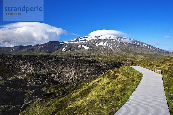 Promenade durch vulkanisches Gestein  Strand Djúpalónssandur  Berg Snæfellsjökull Snaefellsnes im Hintergrund  Island  Europa