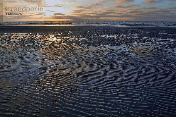Wellen  Plätschern im Sand bei Sonnenuntergang  Norderney  Ostfriesische Inseln  Niedersachsen  Deutschland  Europa