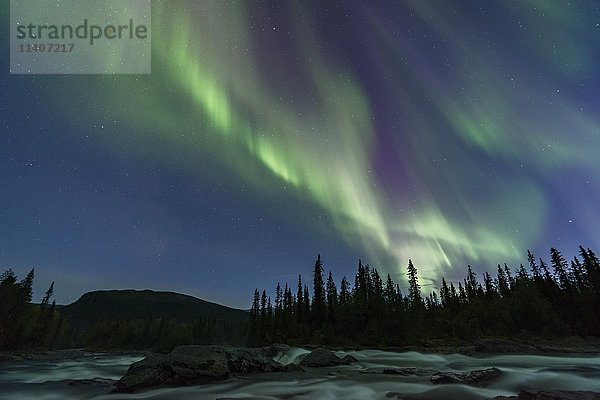 Nordlicht oder Aurora Borealis über dem Fluss Gamajåhkå oder Kamajåkkå  Kvikkjokk  Lappland  Schweden  Europa