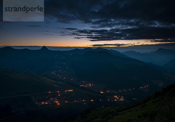 Blick auf das Argenbachtal  beleuchtete Häuser  Landschaft mit dunklen Wolken  Damüls  Bregenzer Wald  Vorarlberg  Österreich  Europa