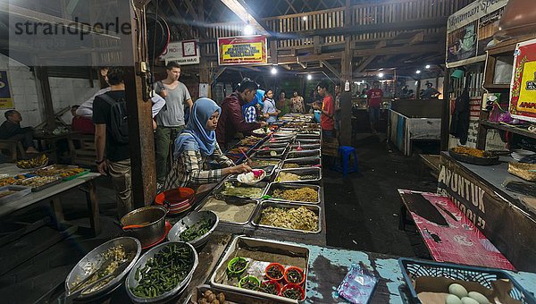 Indonesische Frau nimmt Essen am Stand  Lebensmittelmarkt  Yogyakarta  Java  Indonesien  Asien