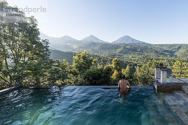 Mann schaut über die Landschaft  Pool  Munduk  Bali  Indonesien  Asien
