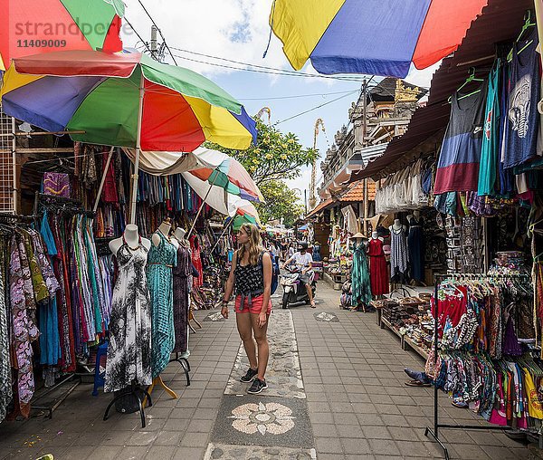 Touristin betrachtet Kleider  Traditioneller Kunstmarkt  Ubud  Bali  Indonesien  Asien