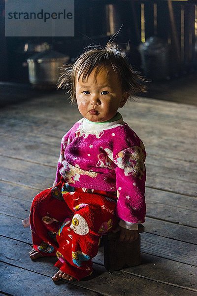 Kleines Mädchen sitzt auf einem Hocker in einer Hütte  Palaung Bergvolk  Palaung Dorf in Kyaukme  Shan Staat  Myanmar  Asien