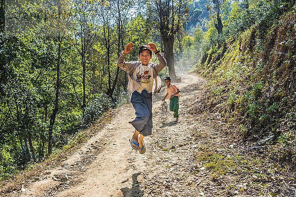 Junge springt fröhlich auf unbefestigter Straße  Palaung Bergvolk  Palaung Dorf in Kyaukme  Shan Staat  Myanmar  Asien
