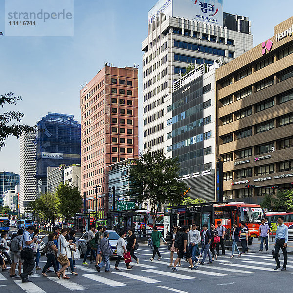 Fußgänger überqueren eine belebte Straße auf einem Zebrastreifen; Seoul  Südkorea'.