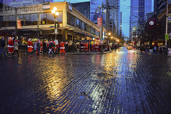 Die Drunk santas Christmas Party   eine traditionelle jährliche Zusammenkunft von Hunderten von fröhlichen Weihnachtsfeiernden  die durch die Innenstadt von Seattle ziehen und dabei auch einen Halt am weltberühmten Pike Place Public Market machen; Seattle  Washington  Vereinigte Staaten'.