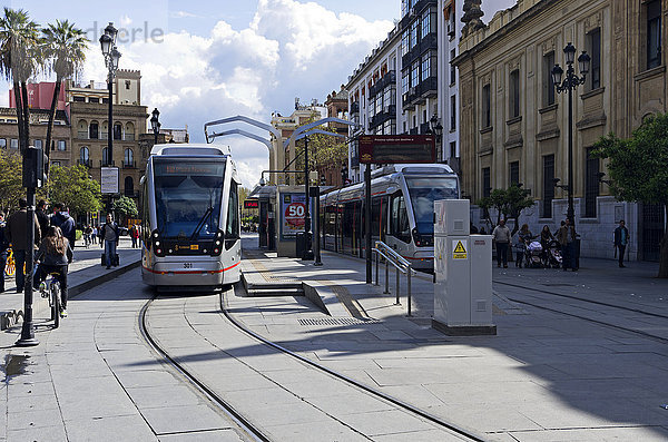 Zwei moderne Straßenbahnen halten im Zentrum von Santa Cruz in Sevilla; Sevilla  Andalusien  Spanien'.