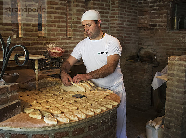 Bäcker bei der Herstellung von Tonis puri  einer Art georgischem Brot  im georgischen Restaurant Bread House; Tiflis  Georgien