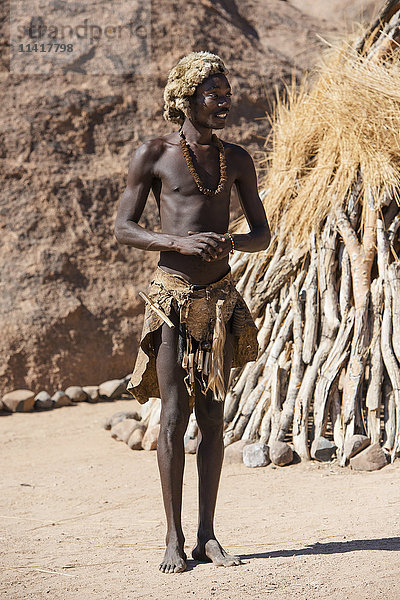 Ein junger Mann in traditioneller Damara-Kleidung posiert im Lebenden Museum der Damara; Namibia'.
