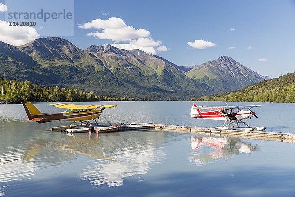Zwei Wasserflugzeuge angedockt an der Trail Lake Float Plane Base an einem klaren Tag  die Kenai Mountains im Hintergrund  Kenai Halbinsel  Süd-Zentral-Alaska  USA  Sommer