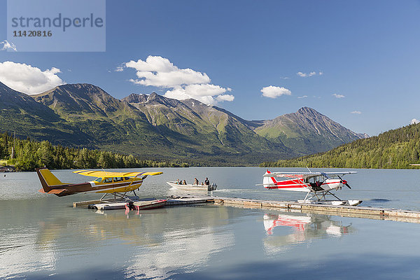 Zwei Wasserflugzeuge angedockt an der Trail Lake Float Plane Base an einem klaren Tag  die Kenai Mountains im Hintergrund  Kenai Penninsula  Southcentral Alaska  USA  Sommer
