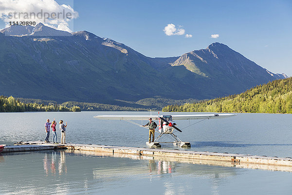Besucher winken dem Piloten eines Super Cub Wasserflugzeugs zu  Trail Lake Float Plane Base  Moose Pass  Kenai Peninsula  Southcentral Alaska  USA