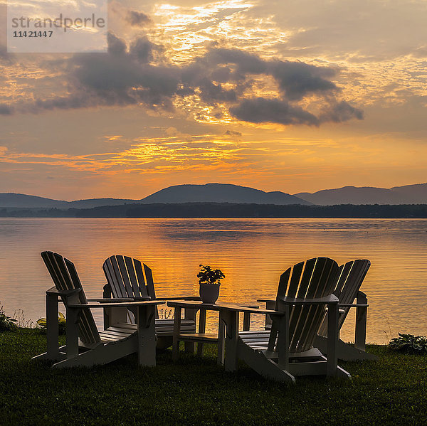 Sonnenuntergang am See mit Silhouetten von Stühlen am Kai; Knowlton  Quebec  Kanada'.