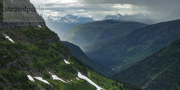 Extreme Gebirgslandschaft mit steilen Hängen und Spuren von Schnee auf üppigem Laub  Glacier National Park; Montana  Vereinigte Staaten von Amerika'.