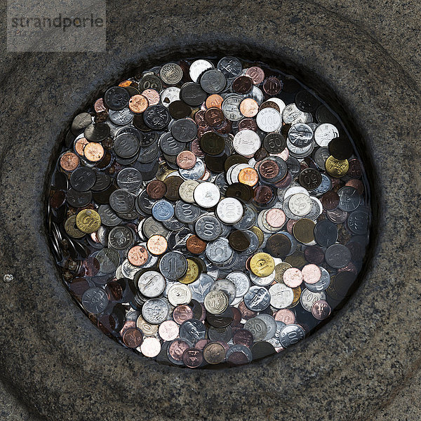 Verschiedene Münzen gestapelt in einem runden Behälter; Seoul  Südkorea