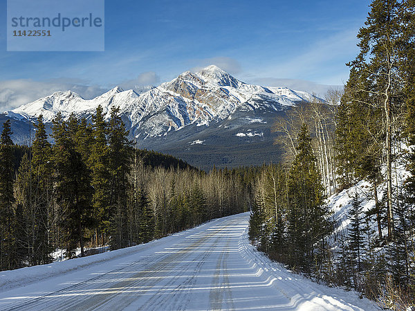 Schneebedeckte Straße und Landschaft mit Bergen und Wäldern im Winter  Jasper National Park; Alberta  Kanada'.