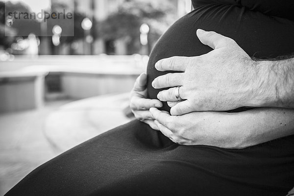 Schwangere Frau hält Hände auf dem Bauch; Waco  Texas  Vereinigte Staaten von Amerika'.