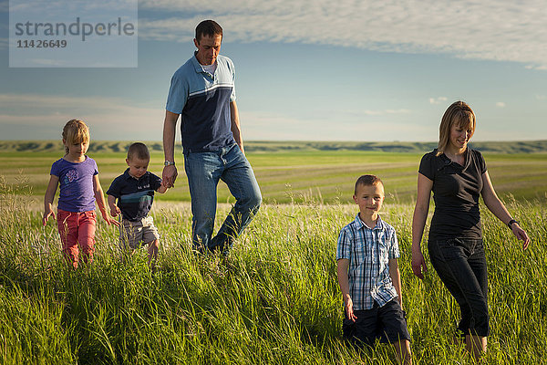 Eine Familie spaziert durch ein Farmfeld; Herschel  Saskatchewan  Kanada'.