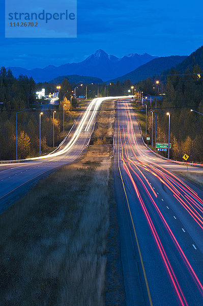 Langzeitbelichtung des Abendverkehrs auf dem Glenn Highway bei Eagle River; Alaska  Vereinigte Staaten von Amerika'.