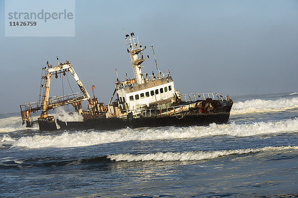 Ein rostiges  gesunkenes  verlassenes Schiff in den Wellen des Atlantiks an der namibischen Küste (Zeila Shipwreck); Namibia'.