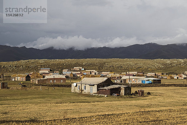 Jesidisches Dorf unter bewölktem Himmel mit Bergen in der Ferne; Jesiden  Provinz Shirak  Armenien'.
