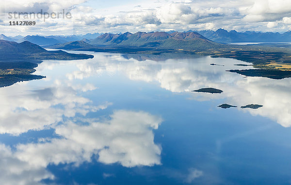 Luftaufnahme von Wolken  die sich auf der glasigen Oberfläche des Nerka Lake spiegeln  im Hintergrund die Wood River Mountains  Wood Tikchik State Park  Südwest-Alaska; Alaska  Vereinigte Staaten von Amerika'.