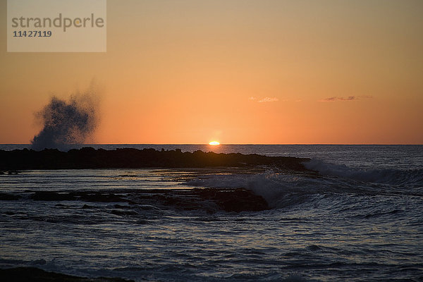 Sonnenuntergang über dem Meer mit plätschernden Wellen; Oahu  Hawaii  Vereinigte Staaten von Amerika'.