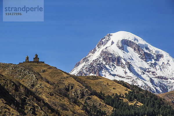 Dreifaltigkeitskirche Gergeti mit dem Berg Kazbek im Hintergrund; Kazbegi  Mtskheta-Mtianeti  Georgien'.