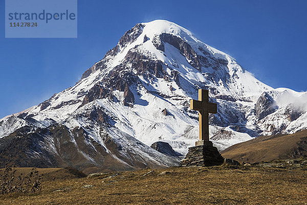 Steinkreuz mit dem Berg Kazbek im Hintergrund; Kazbegi  Mtskheta-Mtianeti  Georgien'.