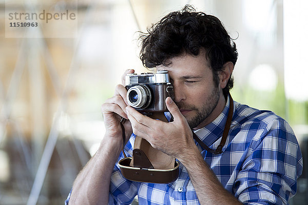 Mann fotografiert mit einer Filmkamera