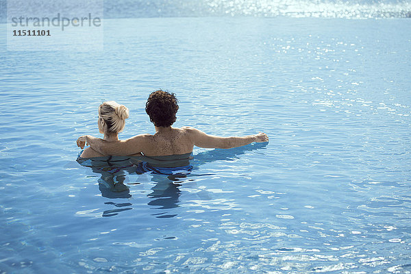 Paar entspannt zusammen im Wasser  Rückansicht
