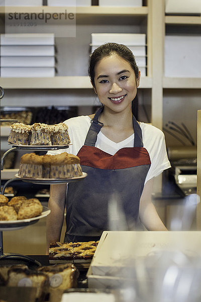 Frau arbeitet hinter Bäckerei-Theke  Porträt