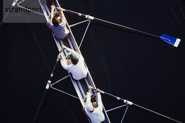 Draufsicht auf die Männer beim Rudern eines Totenkopfbootes während eines Wettbewerbs in Seattle.