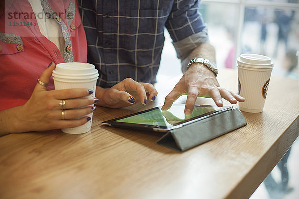 Paar mit digitalem Tablett im Coffee Shop  beschnitten