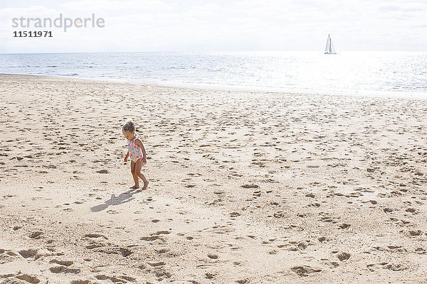 Kleines Mädchen  das am Strand spazieren geht