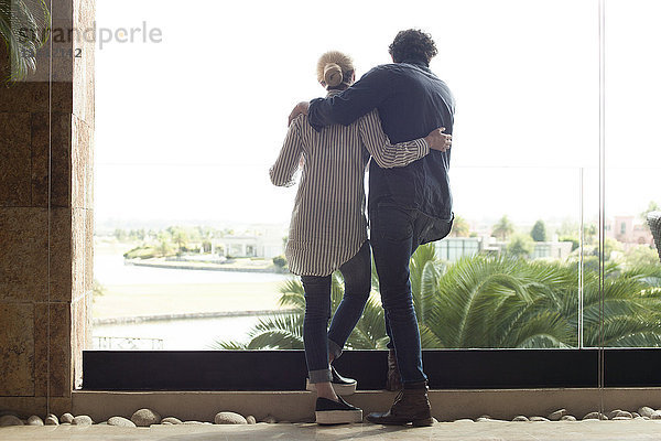 Paar mit Blick aus dem Fenster auf das Resort