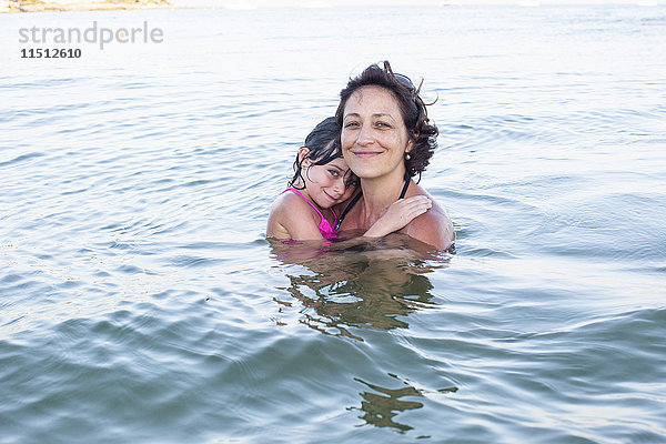 Mutter und Tochter watend im Meer