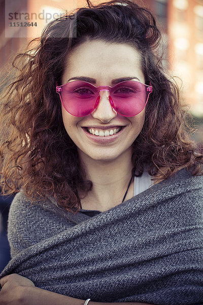 Frau mit rosa Sonnenbrille  fröhlich lächelnd  Portrait