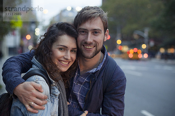 Junges Paar  das sich nachts auf der Stadtstraße umarmt  Porträt