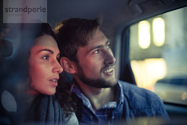 Paar schaut nachts aus dem Autofenster