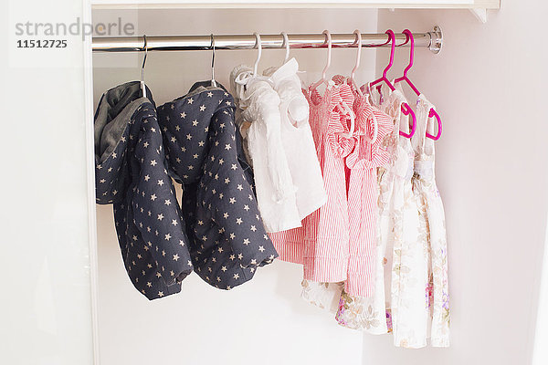 Babykleidung im Schrank hängend
