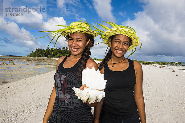 Einheimische Mädchen mit Palmblatthüten posieren in der Lagune von Wallis  Wallis und Futuna  Pazifik