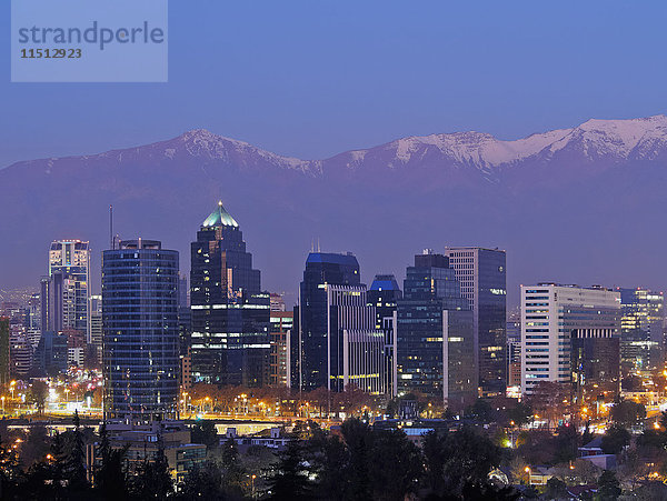 Blick in der Dämmerung vom Parque Metropolitano auf die Hochhäuser des Finanzsektors und die schneebedeckten Berge dahinter  Santiago  Chile  Südamerika