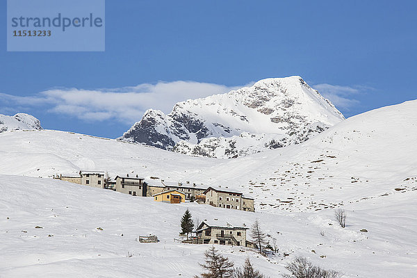 Die verschneiten Hütten umrahmen den Gipfel des Tambo im Hintergrund  Andossi  Splugatal  Provinz Sondrio  Valtellina  Lombardei  Italien  Europa